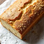 رغيف خبز باليو محلي بقشرة ذهبية وقطع ناعمة على لوح خشبي