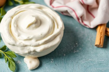 وعاء كريم فريش منزلي مع ملعقة وخبز مقرمش