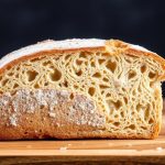 رغيف خبز مقطع يظهر قشرته الذهبية والقوام الداخلي مع تلميح لرائحة خميرية