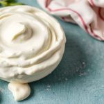 وعاء كريم فريش منزلي مع ملعقة وخبز مقرمش