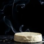 جبنة كريمية مدخنة ناعمة على لوح تقديم مع زعتر وشرائح خبز