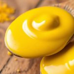 بذور خردل أثرية وجرة خردل حديثة على طاولة خشبية