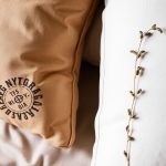 وسادة أحلام عُشبية محشوة بأعشاب مهدئة بجانب كتاب وشمعة