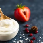 وعاء زبادي وملعقة يرمزان لإعادة استخدام بادئ الزبادي وأسرار التخمر