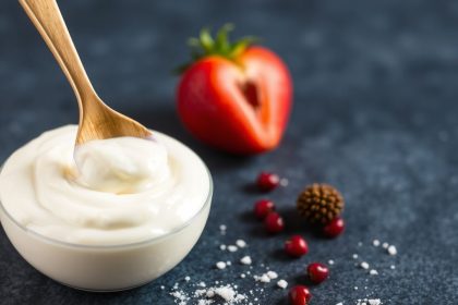 وعاء زبادي وملعقة يرمزان لإعادة استخدام بادئ الزبادي وأسرار التخمر