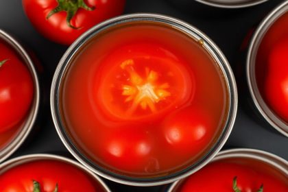 طماطم معلبة كاملة تسبح في سائل عصيري أحمر