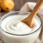 أطباق زبادي كريمي منزلي مع ملاعق وحبوب بادئات التخمير