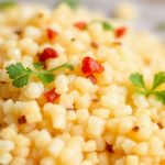 Close-up bowl of fluffy couscous with herbs, lemon, and roasted vegetables